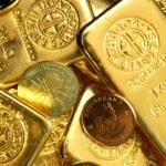 Close-up of shiny gold bars and coins, representing wealth and fortune.